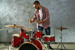 © Africa Studio - Musician playing the drums on grey wall background