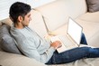 © WavebreakmediaMicro - Handsome man using laptop on the sofa