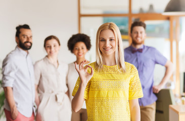 Poster - happy woman showing ok over creative office team