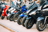 Motorbike, motorcycle scooters parked in row in city street