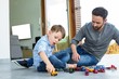 © Wavebreak Media - Father and son playing with toy cars at home