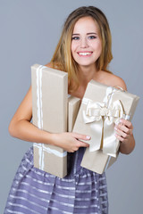 Portrait of a beautiful happy woman in gala dress holding present boxes