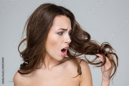 Plakat Rozczarowana kobieta patrząc na jej włosy