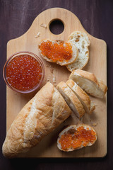 Wall Mural - Wooden chopping board with salmon red caviar and french baguette