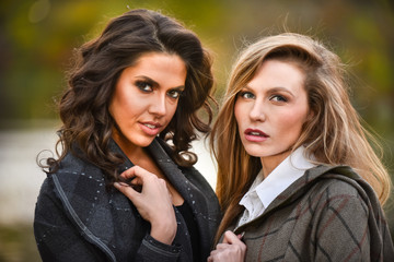 Wall Mural - Two beautiful girls against an autumn nature background.