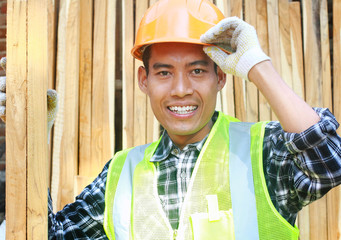 Canvas Print - Portrait of a smiling carpenter holding wood