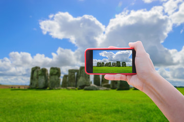 Fototapete - Girl taking pictures on a mobile phone, Stonehenge, Wiltshire, UK.