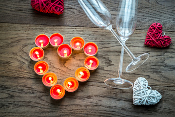 Wall Mural - Burning candles in the shape of heart with two flutes