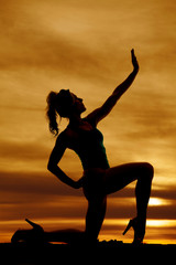 Canvas Print - silhouette of a woman on one knee reaching up in the sunset