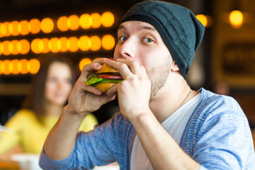 man in hands holds a burger. Man holding a burger and smiling