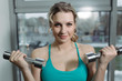© antgor - Beautiful sportswoman doing exercise for biceps with dumbbell in gym