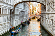 Tourists In Gondolas Sailing Under The Bridge Of Sighs In Venice
