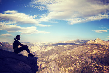 Vintage stylized silhouette of a woman watching mountain view.