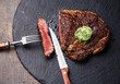 Medium rare grilled Black Angus Steak Ribeye with herb butter on