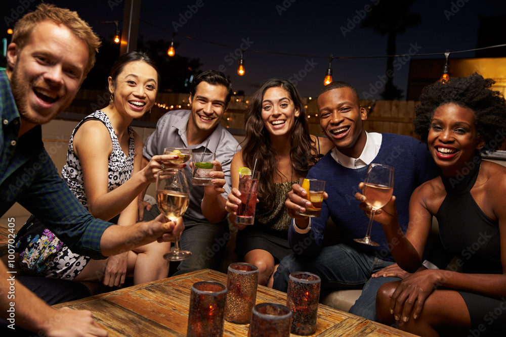 Portrait Of Friends Enjoying Night Out At Rooftop Bar - obrazy, fototapety, plakaty 