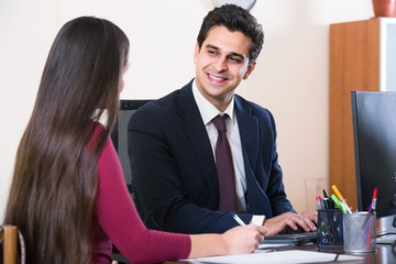 agent listening to customer and smiling in agency