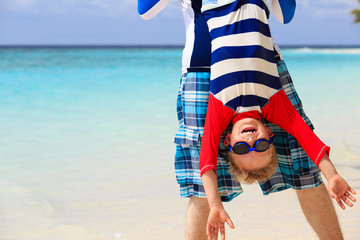 Wall Mural - father and little son playing on summer beach