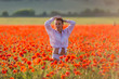 © azazello - Girl at blooming poppy field