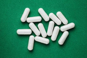 Canvas Print - white capsules pills on green background