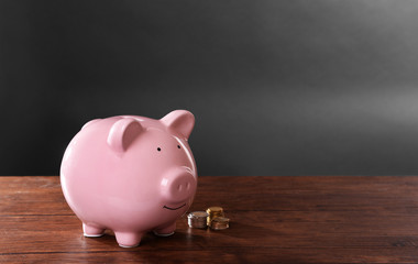 Wall Mural - Piggy bank on a table with coins