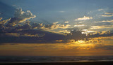 Fototapeta Niebo - Cloudy Sunset Over the Ocean with Sunbeams in the Sky