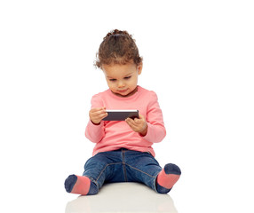 Wall Mural - smiling little baby girl playing with smartphone