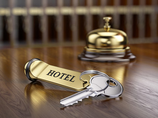 Hotel key and reception bell on reception desk