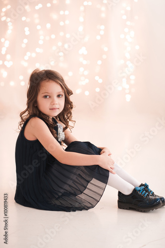 Smiling cute kid girl 5-6 year old sitting on floor over christmas ...