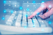 © ra2 studio - Hand pressing keyboard with high tech media icons