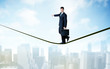 © ra2 studio - Salesman walking on rope above the city