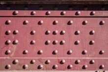 Rivets In A Red Steel Plate