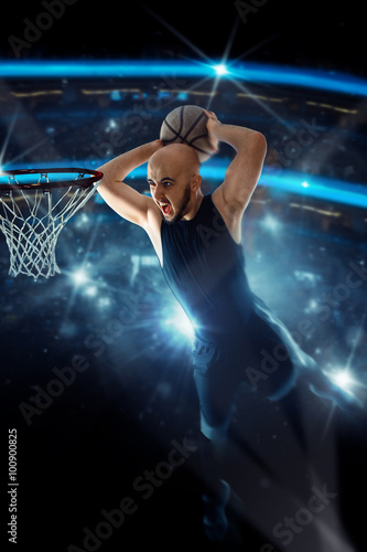 Basketball player in black jersey makes a slam dunk in the game