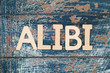 Word alibi written with wooden letters on rustic surface
