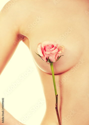 Fototapeta na wymiar Woman covers breast with flower.