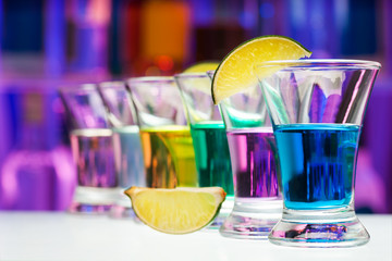 Long perspective row of shots with color drinks