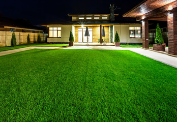 Detached house at night view from outside the rear courtyard. 