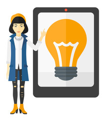 Canvas Print - Woman pointing at tablet computer with light bulb on screen.