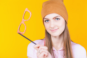 Funny teenage girl holding masquerade glasses for party