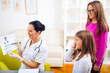 © Mediteraneo - Female pediatrician pointing at eye chart to children