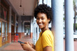 © mimagephotos - Attractive young african woman holding a mobile phone