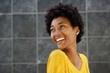 © mimagephotos - Smiling young black woman looking over her shoulder