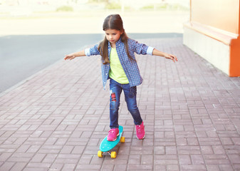 Wall Mural - Fashion kid, little girl riding on skateboard in city