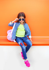 Wall Mural - Fashion little girl child wearing a sunglasses, shirt, jeans and