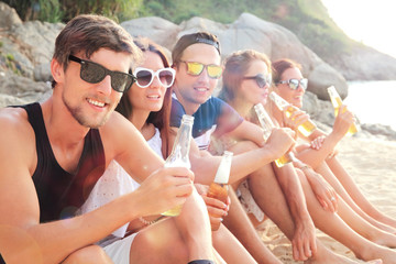 Friends drinking beer on beach