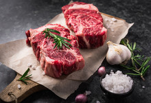 Two Raw Fresh Marbled Meat Black Angus Steak Ribeye, Garlic, Salt And  On Dark Background