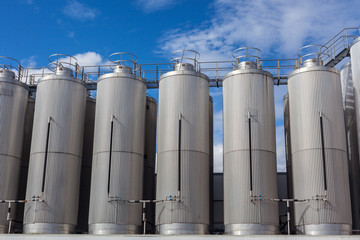 Giant industrial tanks on the bright blue sky