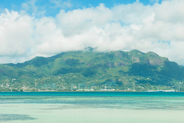 tropical clear water with mountains and blue sky