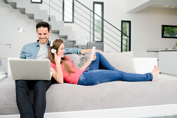 happy young couple relaxed on sofa in a beautiful modern design home