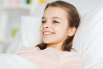 Poster - happy smiling girl lying awake in bed at home