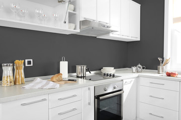 Part of modern kitchen with electric stove oven details, drawers